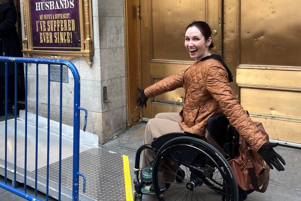 Wheelchair user arriving at a Broadway theater's accessible ramp entrance